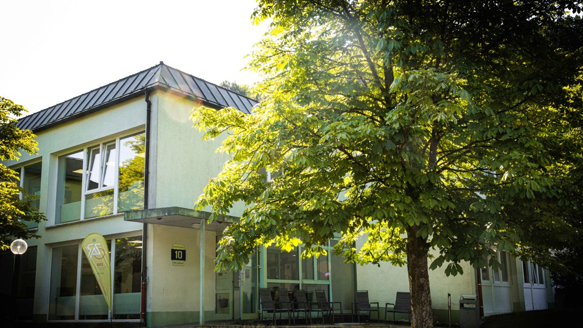 Blick auf das Gebäude des ZAR Landstuhl mit Bäumen im Vordergrund