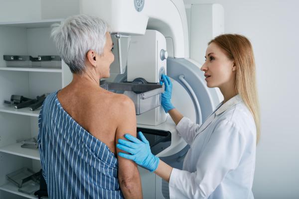 Eine Ärztin führt bei einer Frau eine Brustkrebsuntersuchung mit einem Mammographiegerät durch.