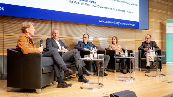 Fünf Expert:innen sitzen auf dem Podium des Neuen Qualitätskongresses Gesundheit 2025 und diskutieren über PROMs und Ergebnisqualität.