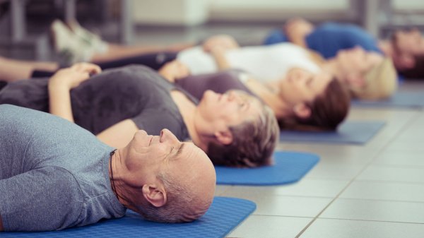 Menschen liegen entspannt auf Gymnastikmatten. Symbolbild zu Unterschieden zwischen Reha und Kur.