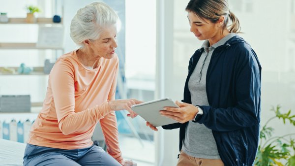 Patientin bespricht digitale Therapieangebote zur Rehabilitation mit einer Fachkraft.