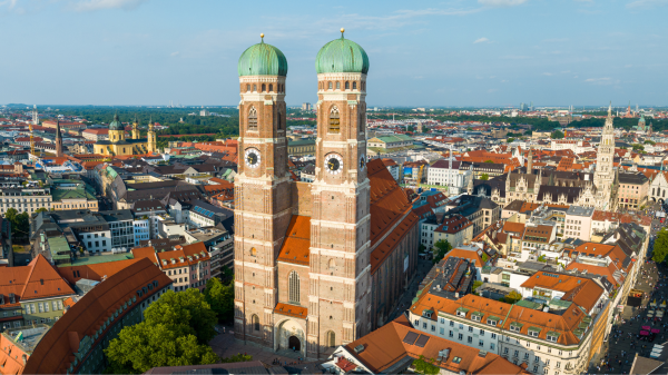Luftaufnahme der Münchner Innenstadt mit den Türmen der Frauenkirche im Vordergrund.