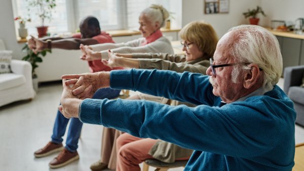 Seniorinnen und Senioren trainieren gemeinsam Beweglichkeit in der geriatrischen Reha.