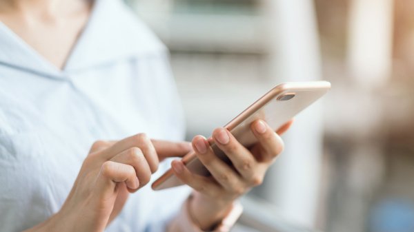 Person nutzt Smartphone für die digitale Nachsorge nach einer Rehabilitationsmaßnahme.