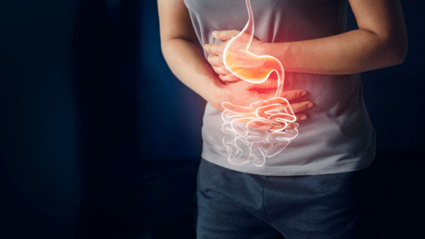 Mann hält sich vor Schmerzen den Bauch und schematische Darstellung des Verdauungstraktes.