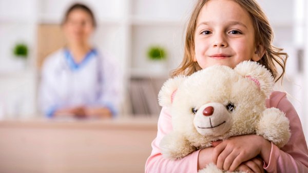 Kind mit Stofftier in einer Rehaeinrichtung für Kinder und Jugendliche.