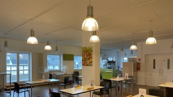 Die Cafeteria ist mit Tischen und Stühlen ausgestattet.