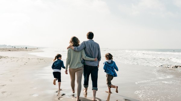 Familie mit zwei Kindern spaziert am Strand während einer Mutter-Vater-Kind-Kur.
