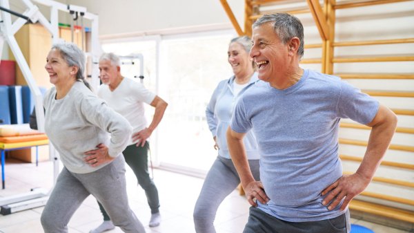 Gruppe von Erwachsenen beim Bewegungstraining in einer Sporthalle. Symbolbild für RV Fit der DRV.