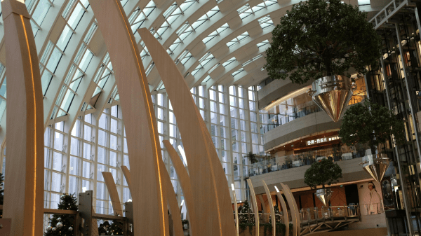 Moderner, lichtdurchfluteter Innenraum eines Gesundheitsgebäudes mit Holzarchitektur, offenem Atrium