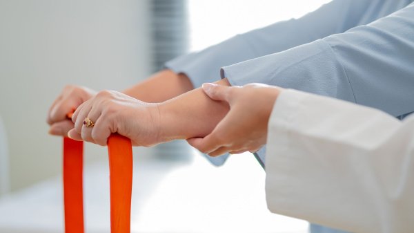 Patientin trainiert mit Therapieband unter Anleitung im Rahmen der IRENA-Nachsorge.