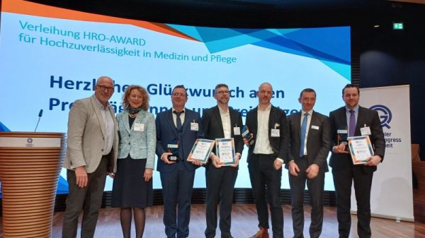 Preisträger:innen des HRO Award 2023 mit Urkunden auf der Bühne