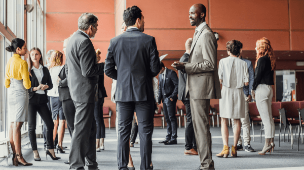 Mehrere Personen stehen in einem Raum und unterhalten sich miteinander