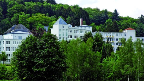 Die VITREA Klinik Hagen-Ambrock liegt eingebettet in ein waldreiches Erholungsgebiet – Blick auf das Klinikgebäude umgeben von Bäumen und Natur.
