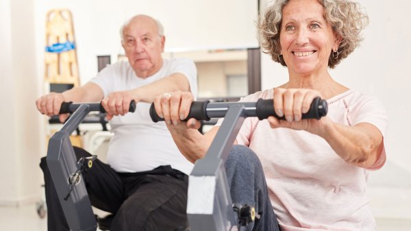 Patienten trainieren an Ergometern im Rahmen einer kardiologischen Rehabilitation.