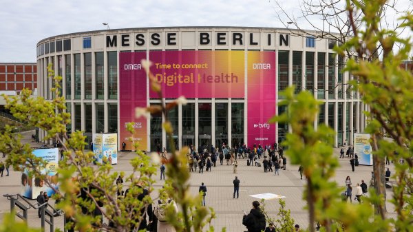 Messe Berlin mit DMEA-Banner „Digital Health“ und Besucher:innen vor dem Eingang.