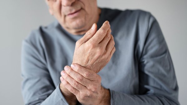 Mann hält schmerzendes Handgelenk. Symbolbild für Reha bei rheumatologische Erkrankungen.