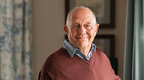 Älterer Mann blickt zuversichtlich in die Kamera während einer Rehabilitationsmaßnahme.