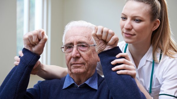 Therapeutin begleitet einen Patienten bei Übungen in der neurologischen Rehabilitation.