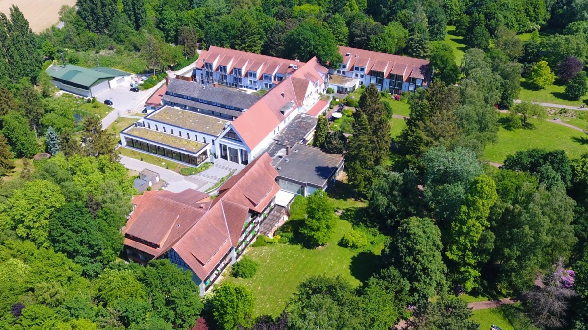Das Bild zeigt eine Luftaufnahme der Rehaklinik mit dem schönen Park.