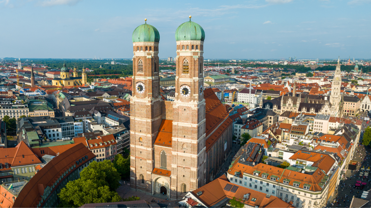 Luftaufnahme der Münchner Innenstadt mit den Türmen der Frauenkirche im Vordergrund.