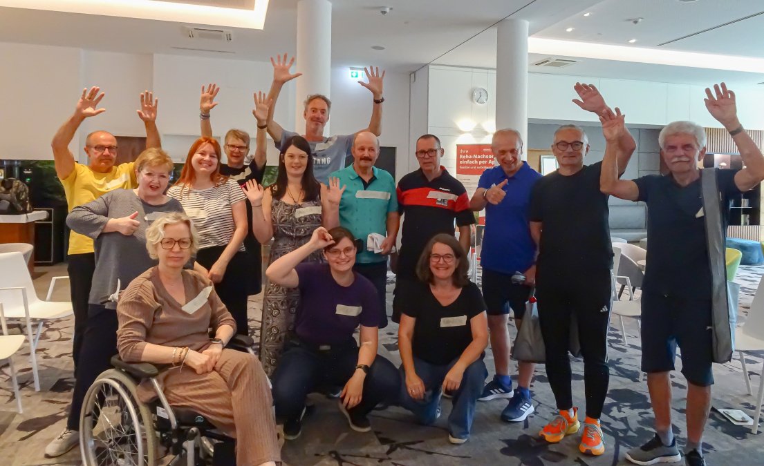Menschen mit Parkinson heben beim Theaterprojekt „Scheiter Heiter“ gemeinsam die Arme.