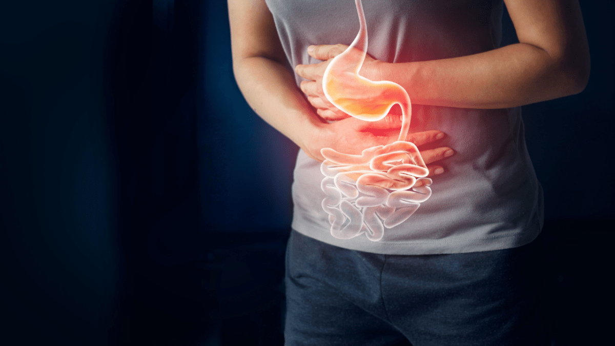 Mann hält sich vor Schmerzen den Bauch und schematische Darstellung des Verdauungstraktes.