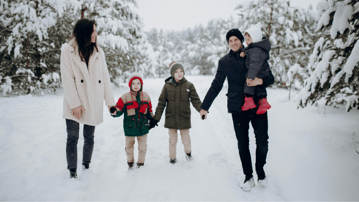 Familie mit Kindern bei einem gemeinsamen Spaziergang im Winter während einer Familienkur