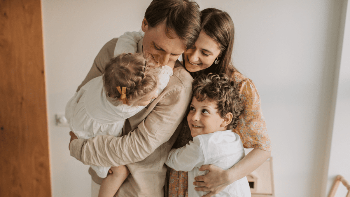 Eltern umarmen ihre Kinder – familiärer Zusammenhalt als Ziel einer Familienkur
