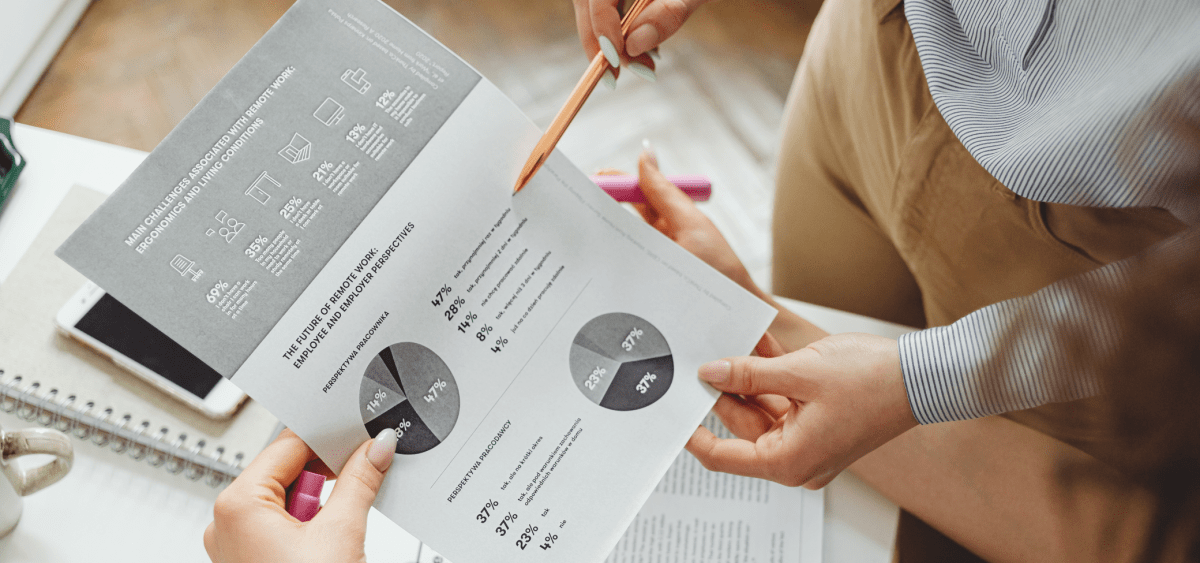 Zwei Personen halten ein ausgedrucktes Dokument mit Diagrammen und Prozentangaben