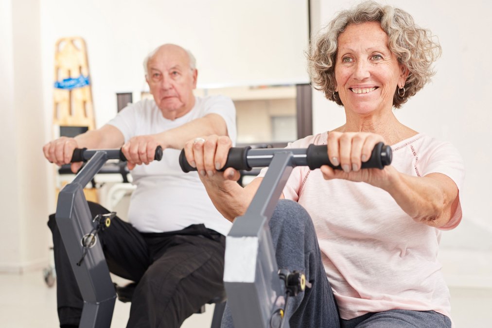 Patienten trainieren an Ergometern im Rahmen einer kardiologischen Rehabilitation.