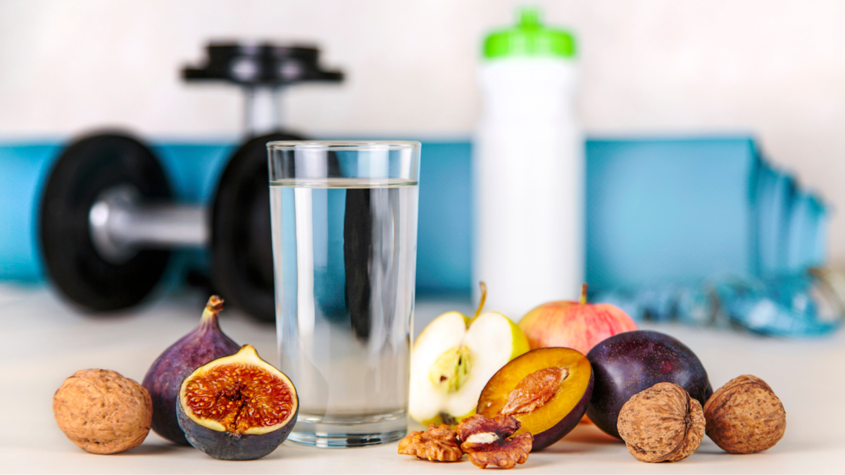 Gesunde Lebensführung: Frisches Obst, Nüsse und ein Glas Wasser vor Sportausrüstung – Symbol für Ernährung, Bewegung und Herzgesundheit