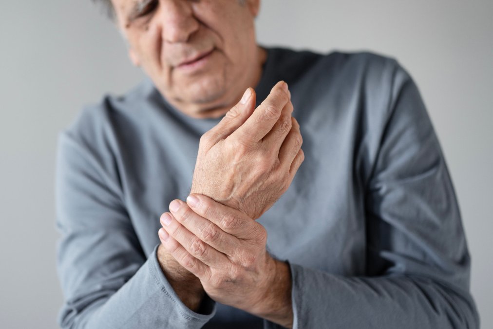 Mann hält schmerzendes Handgelenk. Symbolbild für Reha bei rheumatologische Erkrankungen.